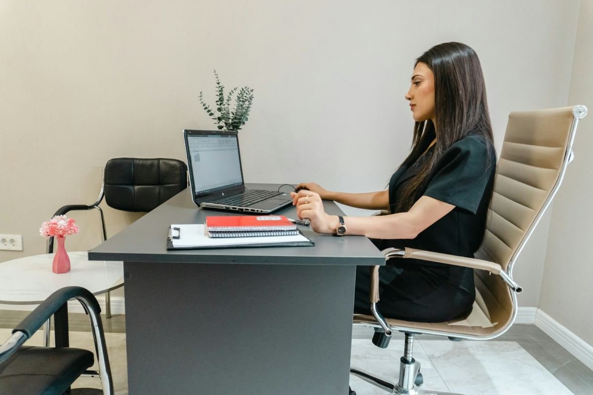 A professional working at a laptop in a bright office